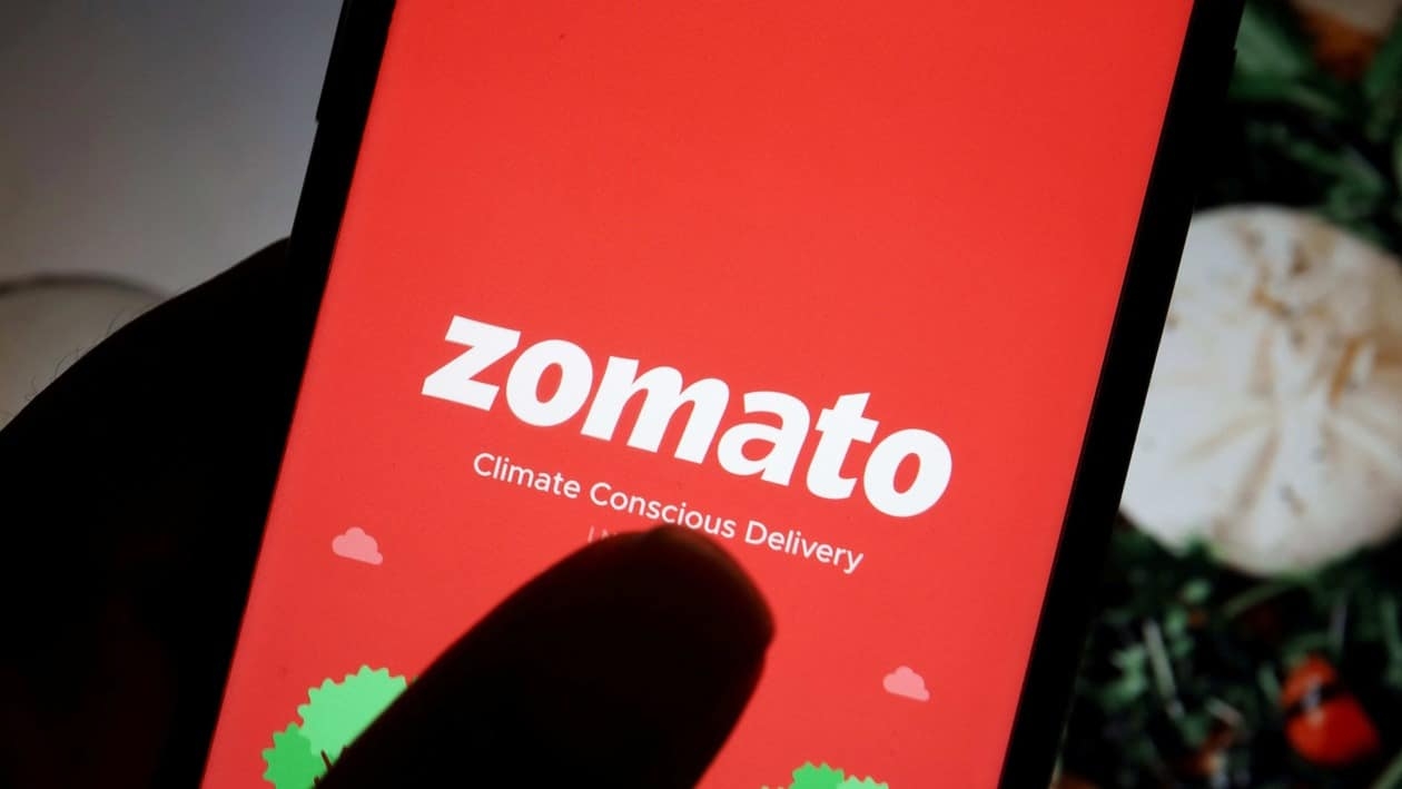FILE PHOTO: The logo of Indian food delivery company Zomato is seen on its app on a mobile phone displayed in front of its company website in this illustration picture taken July 14, 2021. REUTERS/Florence Lo/Illustration/File Photo