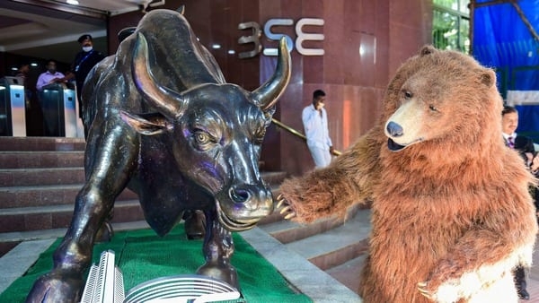 Mumbai: A man dressed as a bear pretends to greet the bull statue, at the BSE building in Mumbai, Friday, Jan. 28, 2022.  (PTI Photo/Shashank Parade)(PTI01_28_2022_000035B)