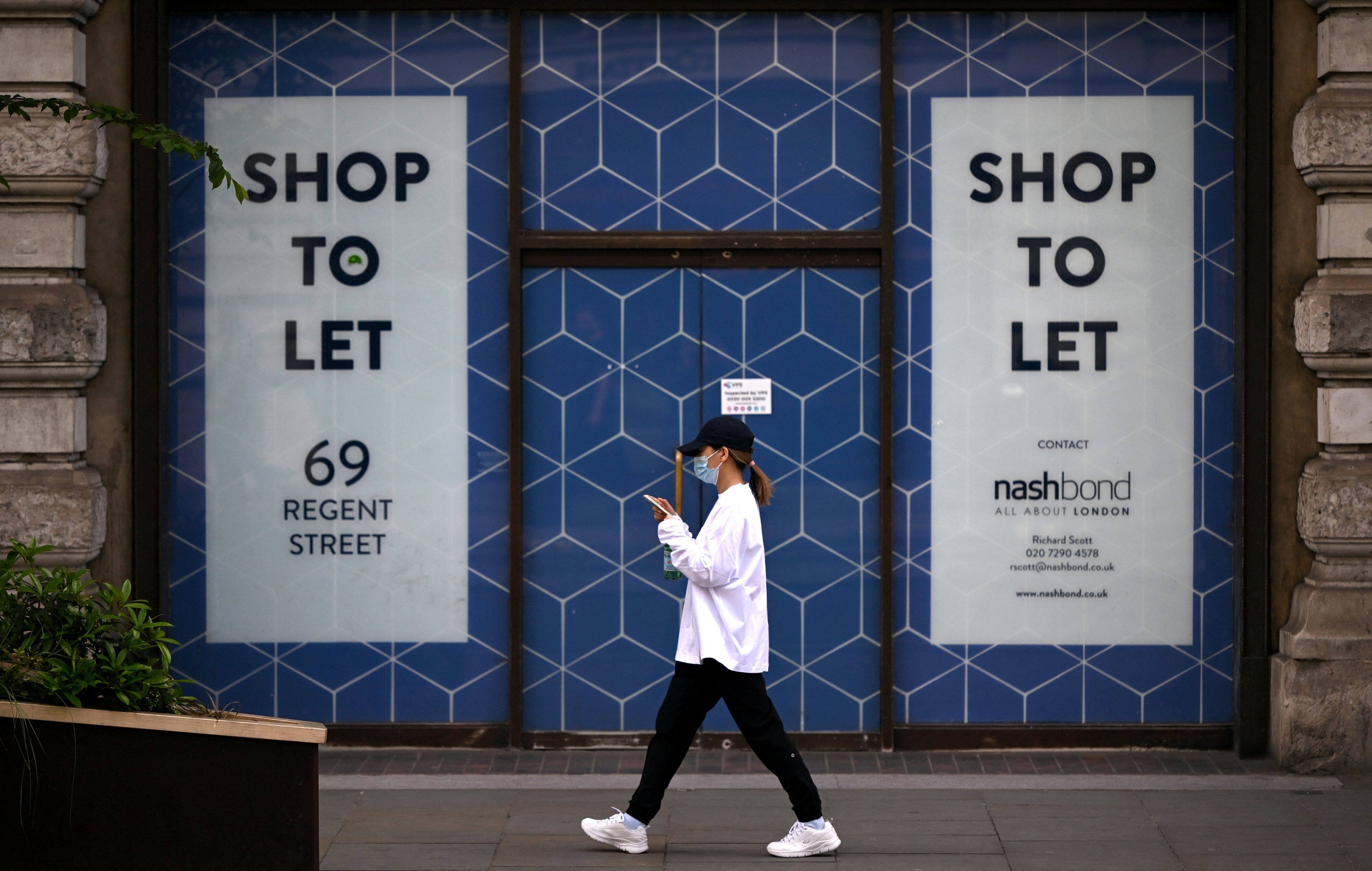 A pedestrian passes a closed-down shop, advertised 'to-let' in London on May 12, 2022. - Britain's economy shrank in March on fallout from soaring inflation, increasing the prospect of the country falling into recession. Official first-quarter data on Thursday showed that following solid output in January, the UK economy posted zero growth the following month and contracted by 0.1 percent in March. (Photo by JUSTIN TALLIS / AFP)