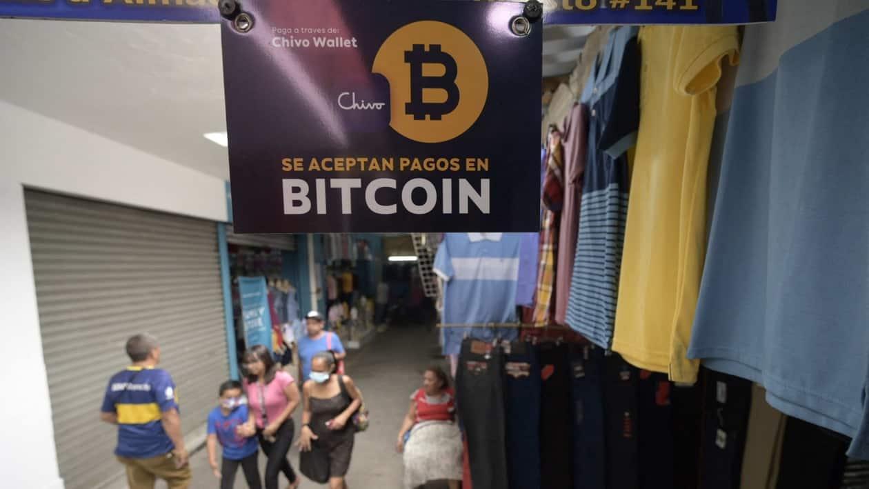 A sign at a stall announces the acceptance of the cryptocurrency bitcoin as payment, in San Salvador, on May 24, 2022. - Shop owners accept payments with bitcoins as the law orders in El Salvador, but as soon as they receive them, they exchange them for dollars to evade the global drop of this cryptocurrency. (Photo by MARVIN RECINOS / AFP)