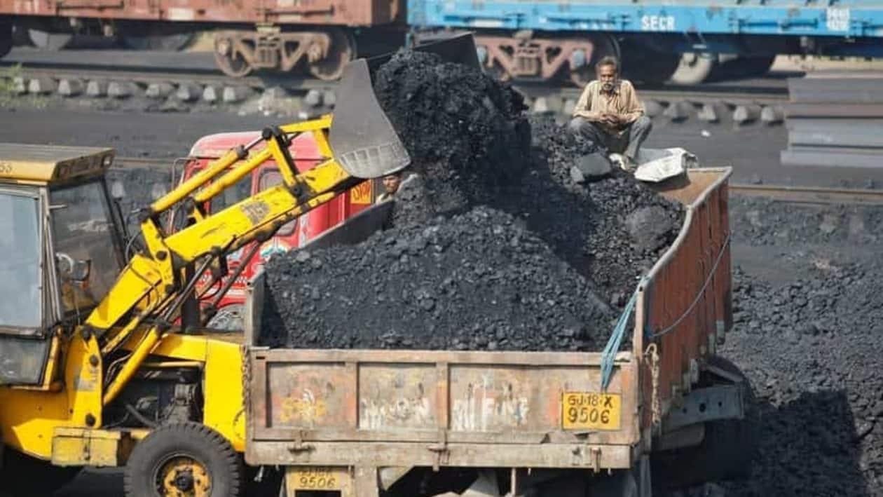 FILE PHOTO: worker sits on a truck being loaded with coal at a railway coal yard on the outskirts of the western Indian city of Ahmedabad November 25, 2013. REUTERS/Amit Dave