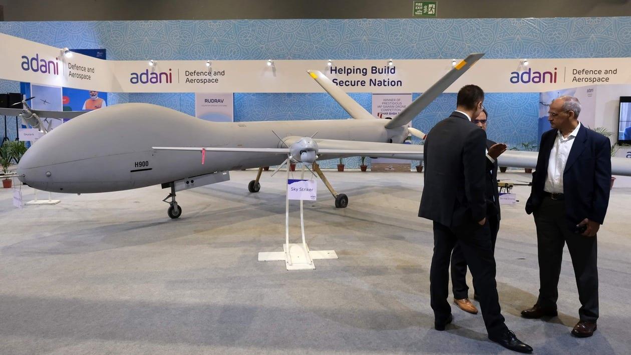 Delegates in front of Adani Defence and Aerospace's Hermes 900, left, and Sky Striker, center, drones on display at the Drone Festival - Bharat Drone Mahotsav 2022, at Pragati Maidan in New Delhi, India, on Friday, May 27, 2022. The Bharat Drone Mahotsav 2022 ends on May 28. Photographer: T. Narayan/Bloomberg