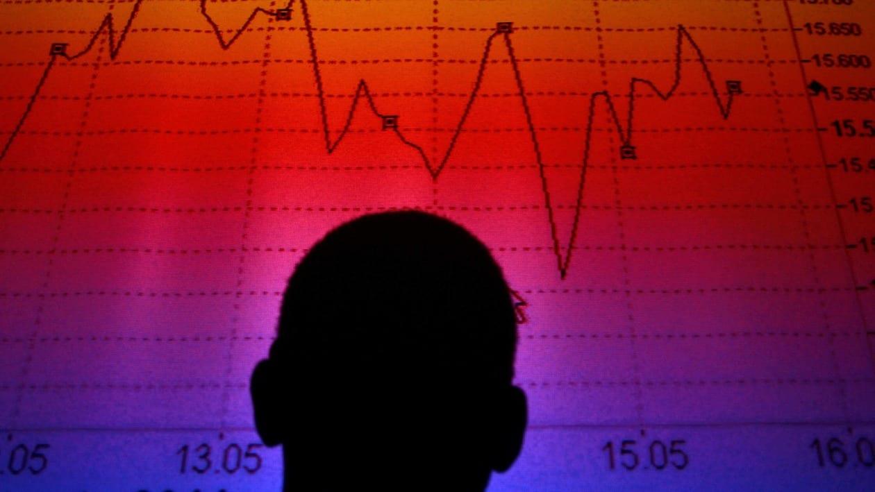 FILE PHOTO: A man is silhouetted in an electronic board showing the FTSE MIB Index for the Italian equity market in this photo illustration taken in Rome August  9, 2011.  REUTERS/Tony Gentile/File Photo