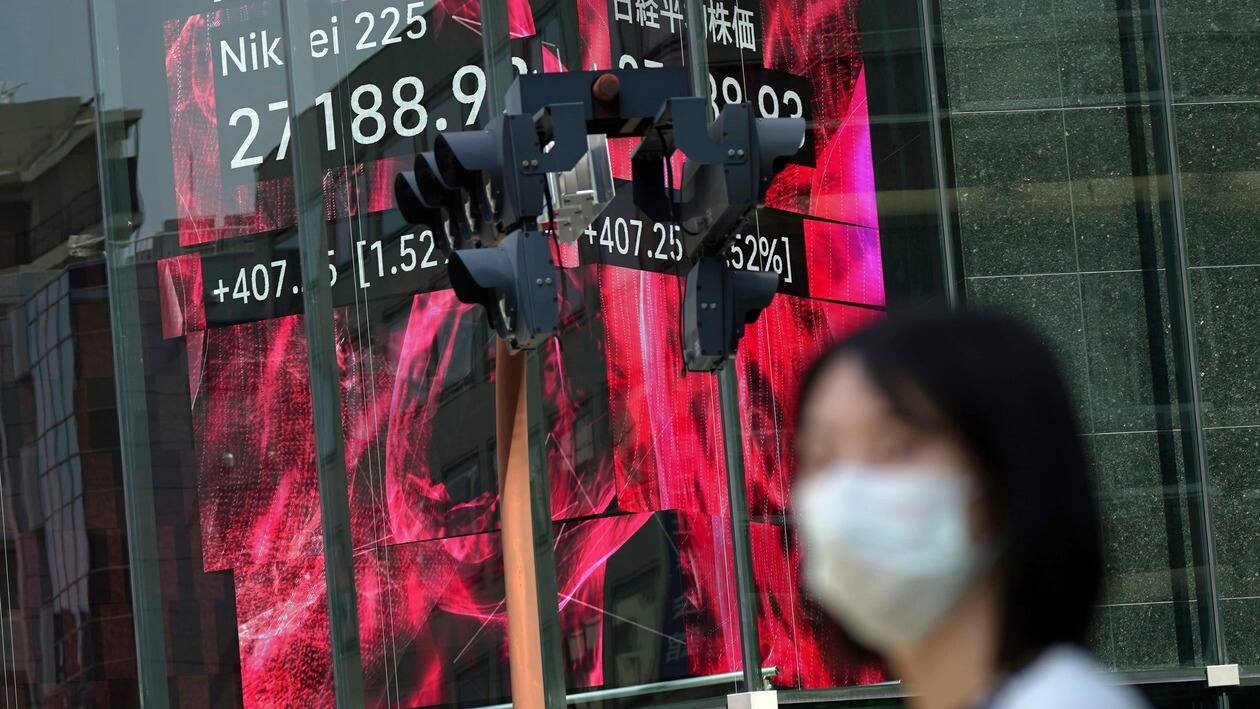 A woman wearing a protective mask stands in front of an electronic stock board showing Japan's Nikkei 225 index Monday, May 30, 2022, in Tokyo. Asian stocks rose Monday after Wall Street rebounded from a seven-week string of declines and China eased anti-virus curbs on business activity in Shanghai and Beijing. (AP Photo/Eugene Hoshiko)