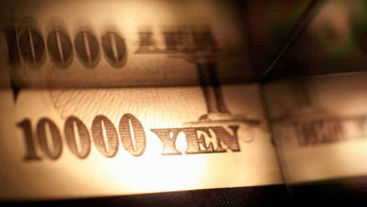 Light is cast on a Japanese 10,000 yen note as it's reflected in a plastic board in Tokyo, in this February 28, 2013 picture illustration. REUTERS/Shohei Miyano/Illustration/File Photo