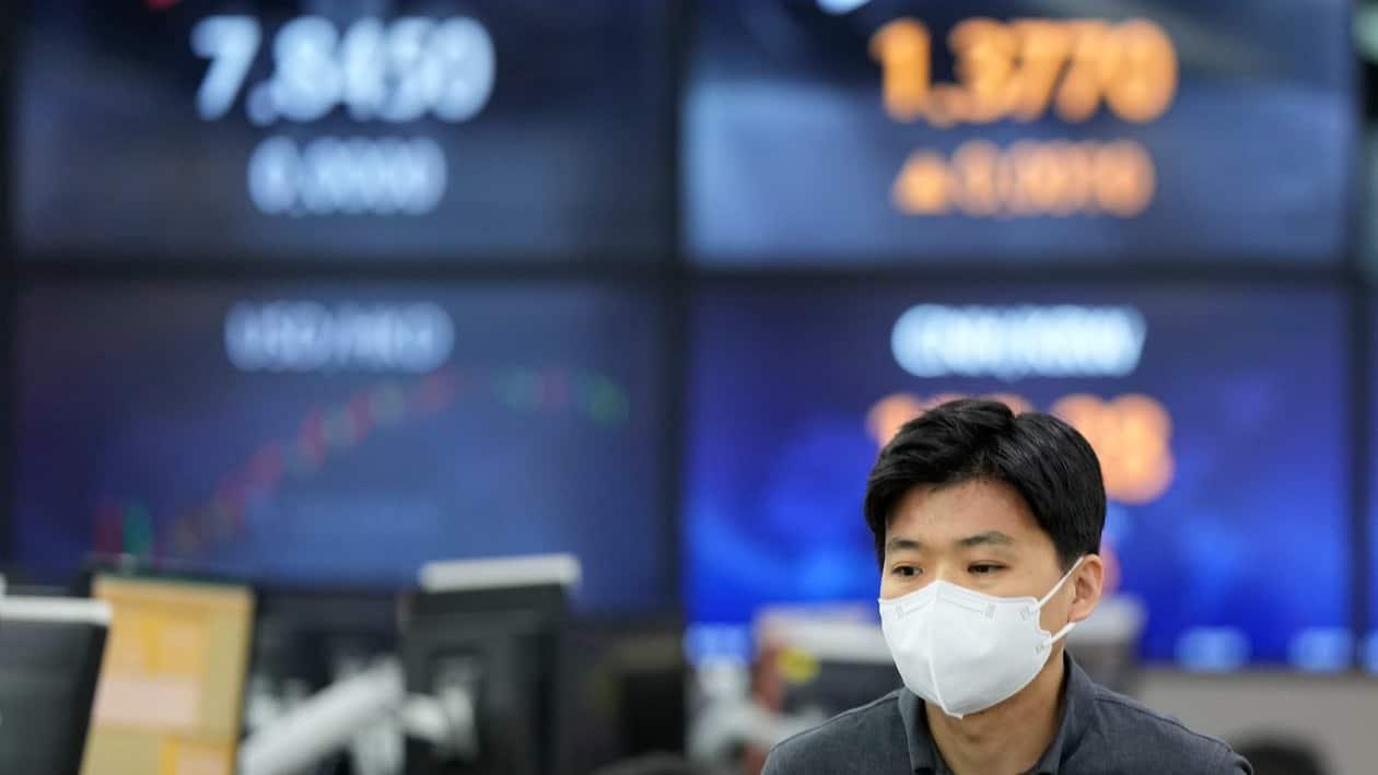 A currency trader walks near the screens showing the foreign exchange rates at a foreign exchange dealing room in Seoul, South Korea, Tuesday, June 7, 2022.  Asian stock markets were mixed Tuesday following a bond sell-off on Wall Street amid anxiety about higher U.S. interest rates. (AP Photo/Lee Jin-man)