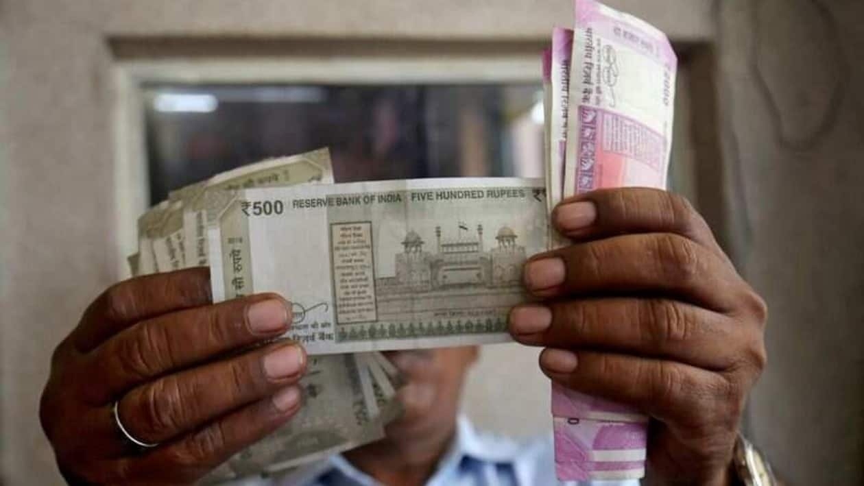 FILE PHOTO: A cashier checks Indian rupee notes inside a room at a fuel station in Ahmedabad, India, September 20, 2018. REUTERS/Amit Dave