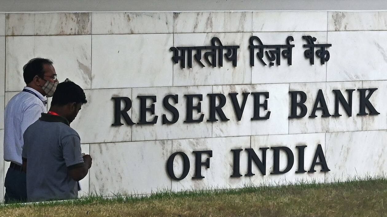 Pedestrians walk past the Reserve Bank of India (RBI) signage at its headquarters in Mumbai on June 8, 2022. - India's central bank on June 8 hiked rates for a second time in as many months, as Asia's third-largest economy reels from galloping inflation in the wake of the Ukraine war. (Photo by Indranil MUKHERJEE / AFP)