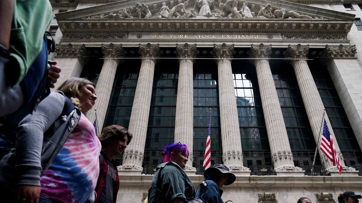 A tour group stops in front of the New York Stock Exchange in New York, Tuesday, June 14, 2022. Wall Street is wobbling between gains and losses Tuesday in its first trading after tumbling into a bear market on worries about a fragile economy and rising rates. (AP Photo/Seth Wenig)