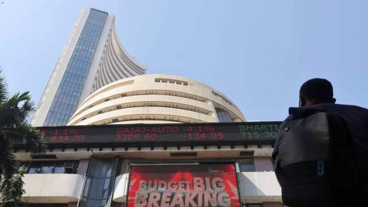FILE PHOTO: A man looks at a screen displaying budget news, on a facade of the Bombay Stock Exchange (BSE) building in Mumbai, India, February 1, 2022. REUTERS/Francis Mascarenhas