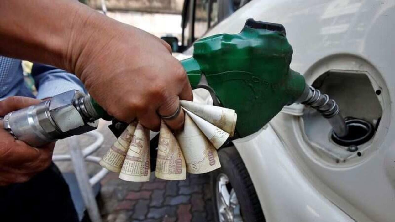 FILE PHOTO: A worker fills diesel in a car as he holds 500 Indian rupee banknotes at a fuel station in Kolkata, India, November 9, 2016. REUTERS/Rupak De Chowdhuri
