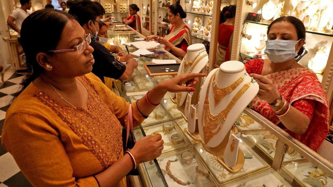 FILE PHOTO: A customer checks a gold necklace before buying it at a jewellery showroom on the occasion of Akshaya Tritiya, a major gold buying festival, in Kolkata, India, May 3, 2022. REUTERS/Rupak De Chowdhuri/File Photo