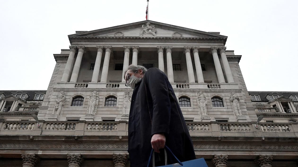 FILE PHOTO: A man wearing a protective face mask walks past the Bank of England (BoE), after the BoE became the first major world's central bank to raise rates since the coronavirus disease (COVID-19) pandemic, in London, Britain, December 16, 2021. REUTERS/Toby Melville/File Photo