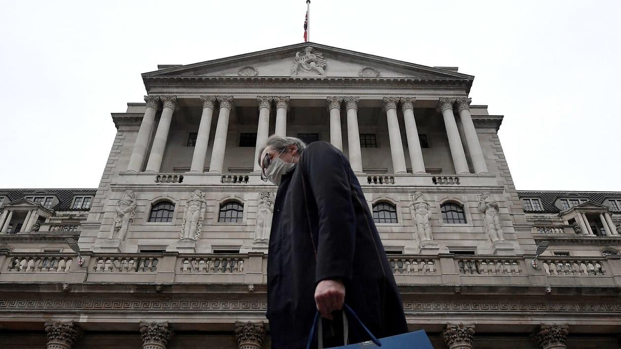 FILE PHOTO: A man wearing a protective face mask walks past the Bank of England (BoE), after the BoE became the first major world's central bank to raise rates since the coronavirus disease (COVID-19) pandemic, in London, Britain, December 16, 2021. REUTERS/Toby Melville/File Photo