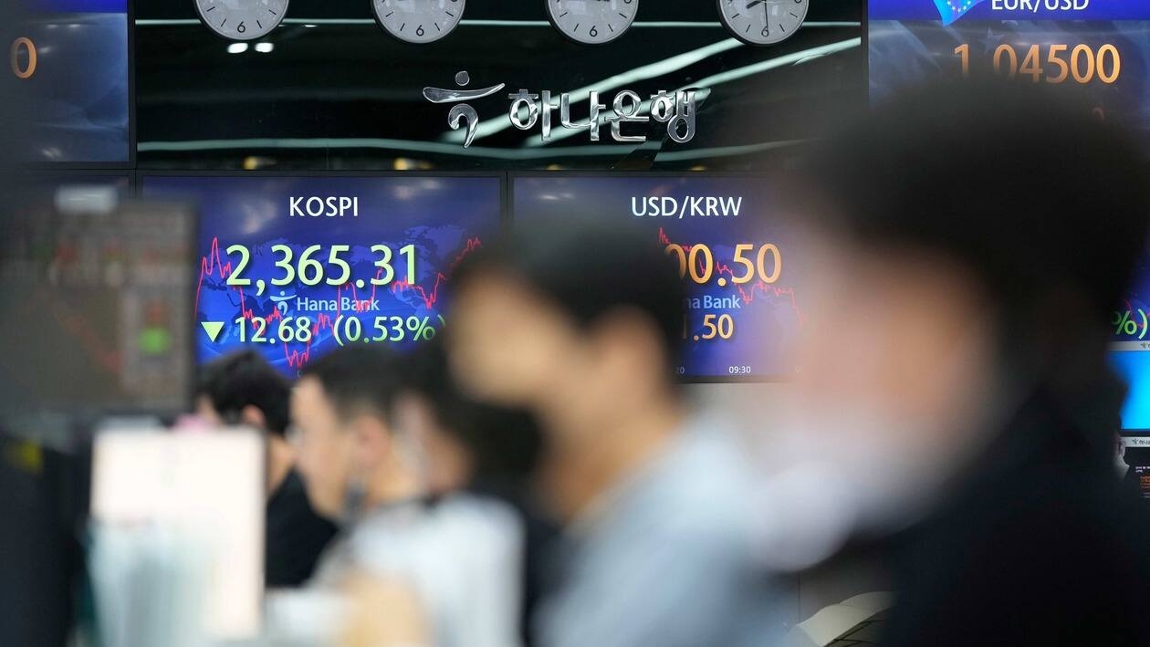 Currency traders watch computer monitors near the screens showing the Korea Composite Stock Price Index (KOSPI), left, and the foreign exchange rates at a foreign exchange dealing room in Seoul, South Korea, Thursday, June 30, 2022. Asian stock markets were mixed Thursday after the U.S. economy contracted and China reported stronger factory activity. (AP Photo/Lee Jin-man)