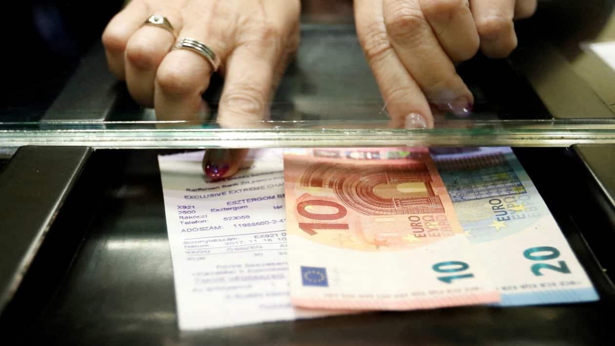 FILE PHOTO: A Hungarian woman exchanges forints for euros at a currency exchange shop in Esztergom, Hungary November 11, 2017. Picture taken November 11, 2017. REUTERS/Laszlo Balogh//File Photo