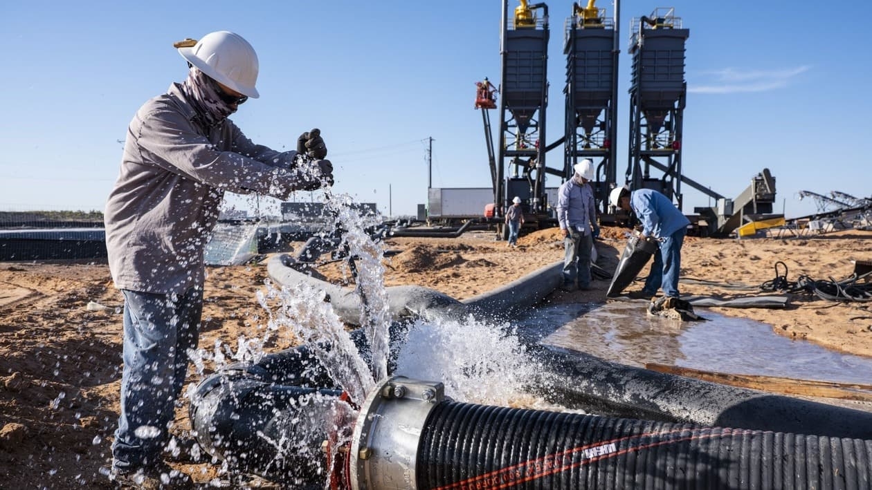 Workers change a water pipe during a Nomad Proppant LLC mobile mining operation in Big Spring, Texas, US, on Tuesday, June 21, 2022. Texas crude producers are facing a sand shortage of more than 1 million tons and prices that have jumped 150%. Photographer: Matthew Busch/Bloomberg