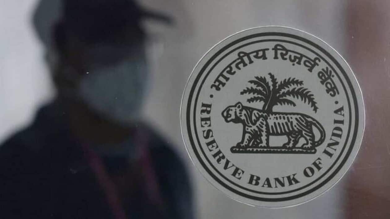 FILE PHOTO: A man walks behind the Reserve Bank of India (RBI) logo inside its headquarters in Mumbai, India, April 8, 2022. REUTERS/Francis Mascarenhas