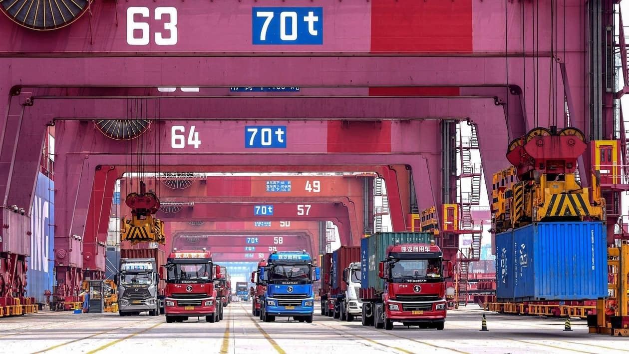 Cranes load containers onto trucks at a port in Qingdao, in China's eastern Shandong province on July 13, 2022. (Photo by AFP) / China OUT