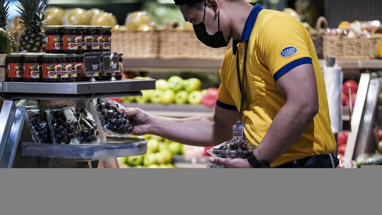 An employee arranges fruit at a supermarket in the Venice Grand Canal Mall in Taguig City, Metro Manila, the Philippines, on Tuesday, July 12, 2022. Philippine central bank Governor�Felipe Medalla�said he won�t rule out at least 100 basis points more of rate hikes this year that would take the policy rate to 3.5% as inflation quickened. Photographer: Veejay Villafranca/Bloomberg