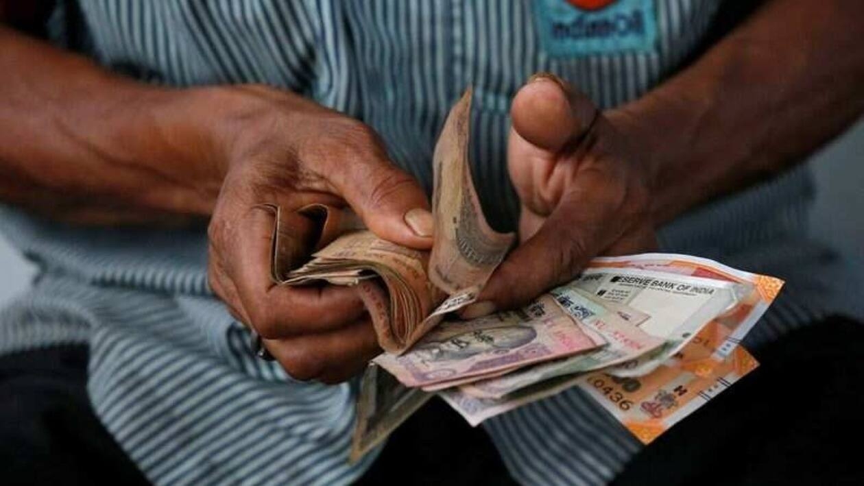 FILE PHOTO: An attendant at a fuel station arranges Indian rupee notes in Kolkata, India, August 16, 2018. REUTERS/Rupak De Chowdhuri