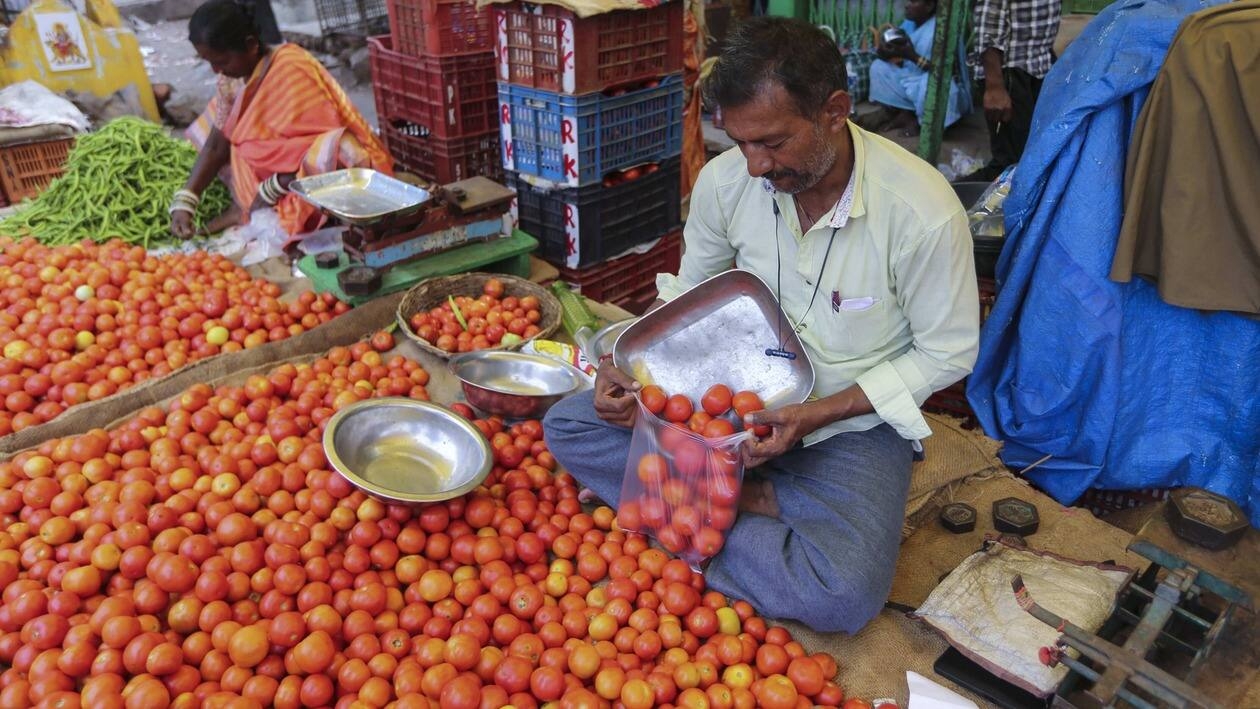 A vendor puts tomatoes in a single use plastic cover at a wholesale vegetable market in Hyderabad, India, Thursday, June 30, 2022. India banned some single-use or disposable plastic products Friday as a part of a longer federal plan to phase out the ubiquitous material in the nation of nearly 1.4 billion people. (AP Photo/Mahesh Kumar A.)