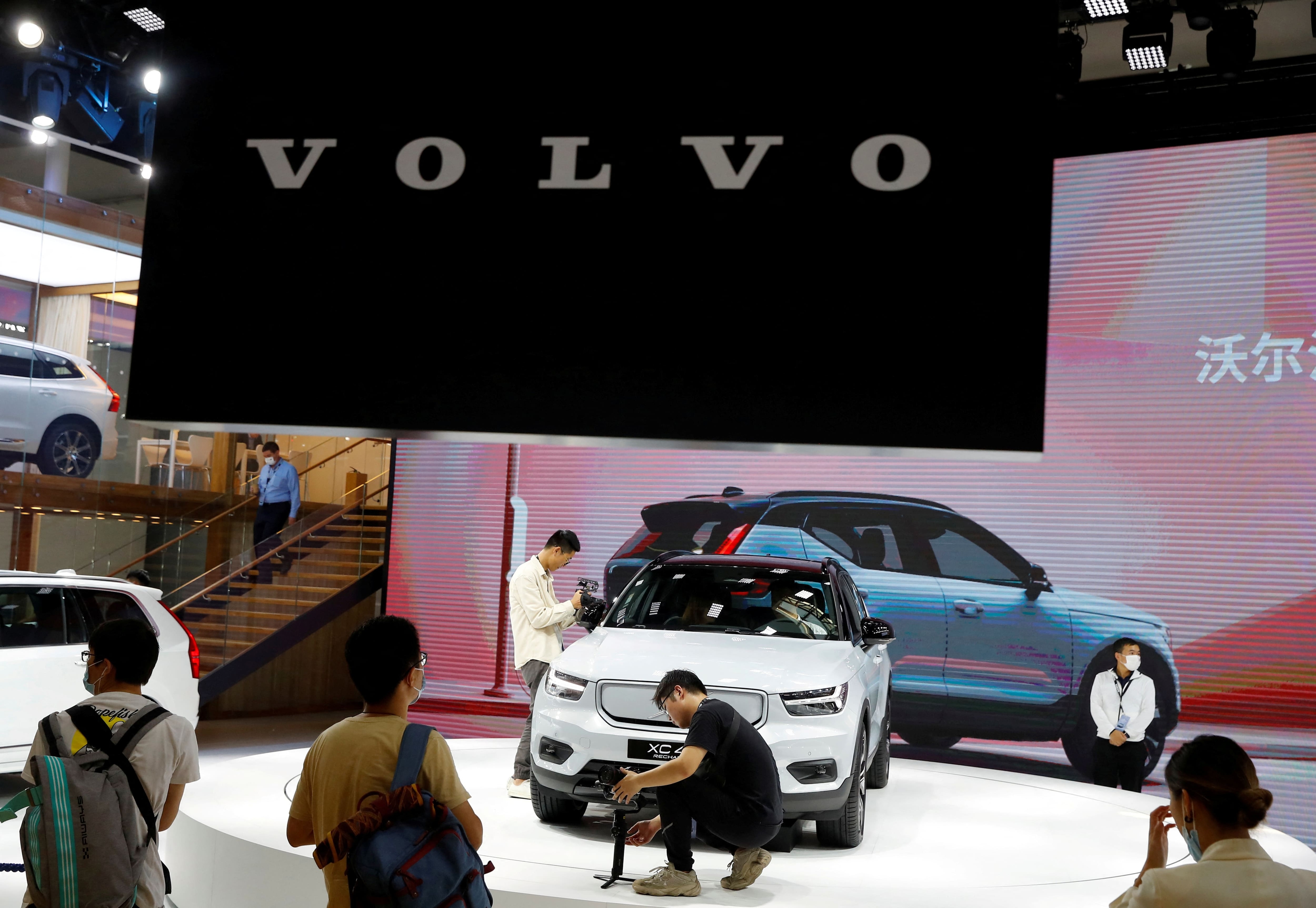 FILE PHOTO: People look at a Volvo XC40 car during the Beijing International Automotive Exhibition, or Auto China show, in Beijing, China September 26, 2020. REUTERS/Thomas Peter/File Photo  GLOBAL BUSINESS WEEK AHEAD