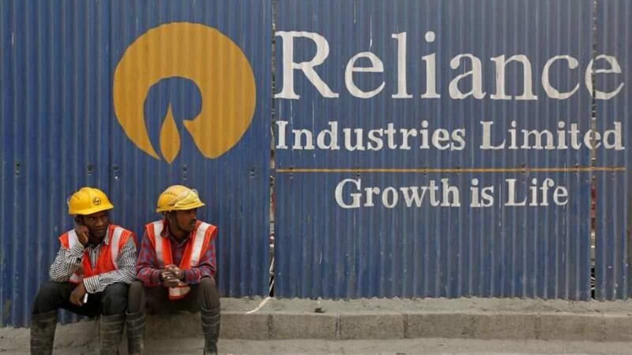 FILE PHOTO: Labourers rest in front of an advertisement of Reliance Industries Limited at a construction site in Mumbai, India, March 2, 2016. REUTERS/Shailesh Andrade