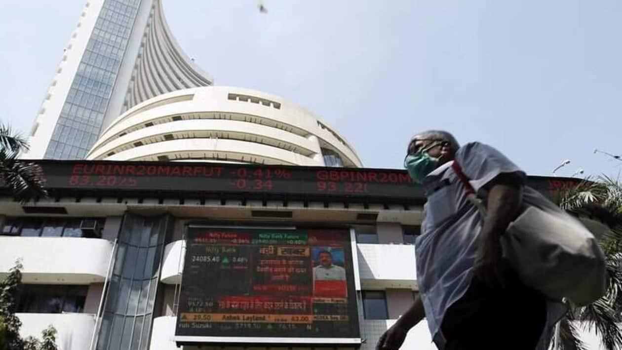 FILE PHOTO: A man wearing a protective mask walks past the Bombay Stock Exchange (BSE) building in Mumbai, India, March 13, 2020. REUTERS/Francis Mascarenhas