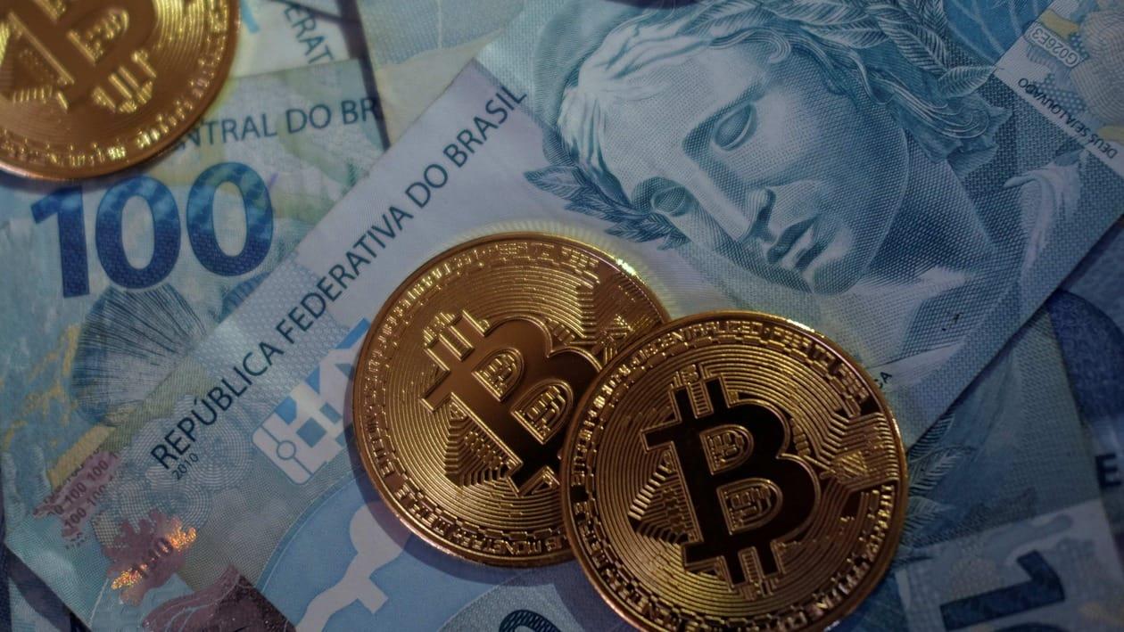 FILE PHOTO: Representations of Bitcoin cryptocurrency are seen over Brazilian Real notes in this illustration picture taken May 25, 2021. REUTERS/Ricardo Moraes/Illustration/File Photo