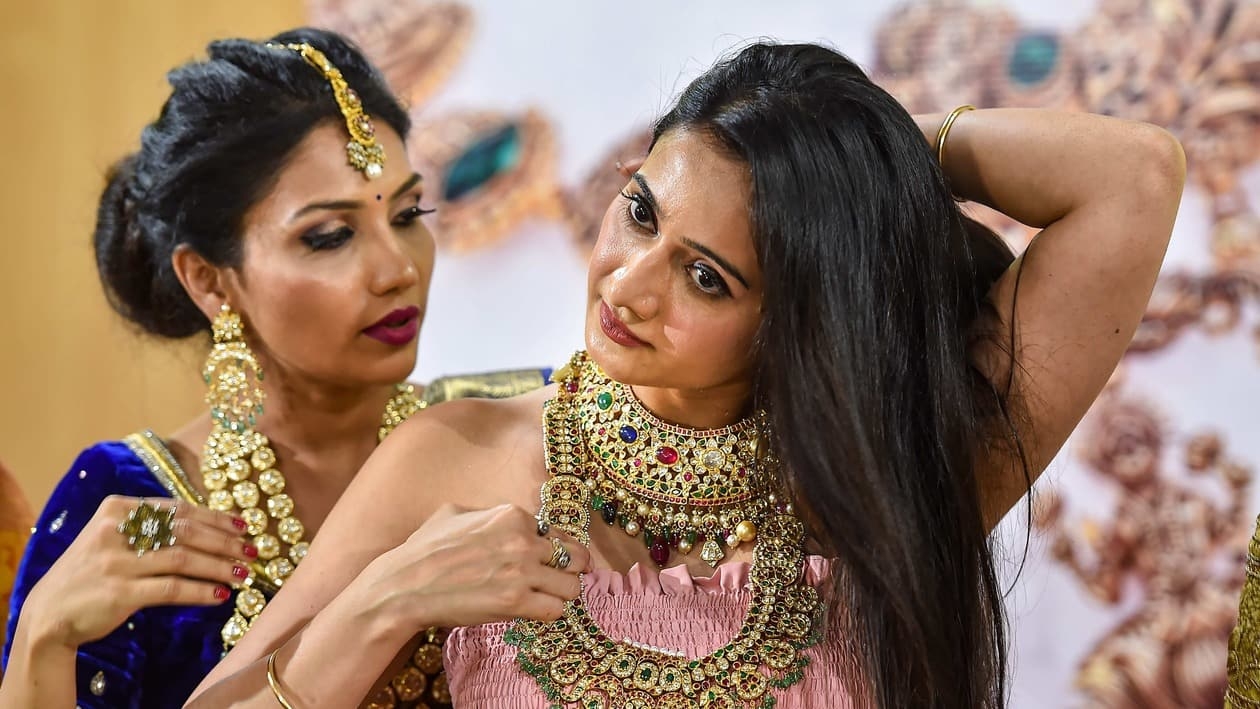 Bengaluru: Kannada film actor Harshika Poonacha (R) with a model showcases antique jewellery during a press conference ahead of 'Asia Jewels Show 2022', in Bengaluru, Monday, July 25, 2022.  (PTI Photo/Shailendra Bhojak) (PTI07_25_2022_000186A)