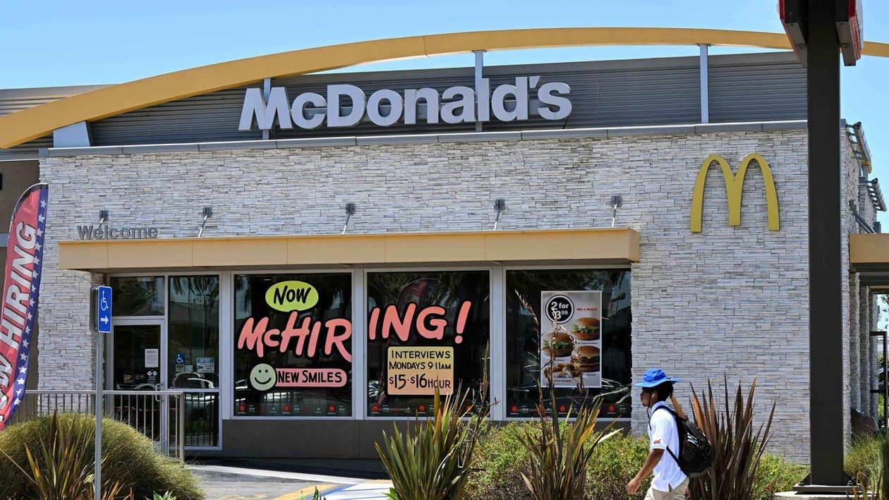 A man walks past a Hiring sign at a McDonald's restaurant in Garden Grove, California on July 8, 2022. (Photo by Robyn BECK / AFP)