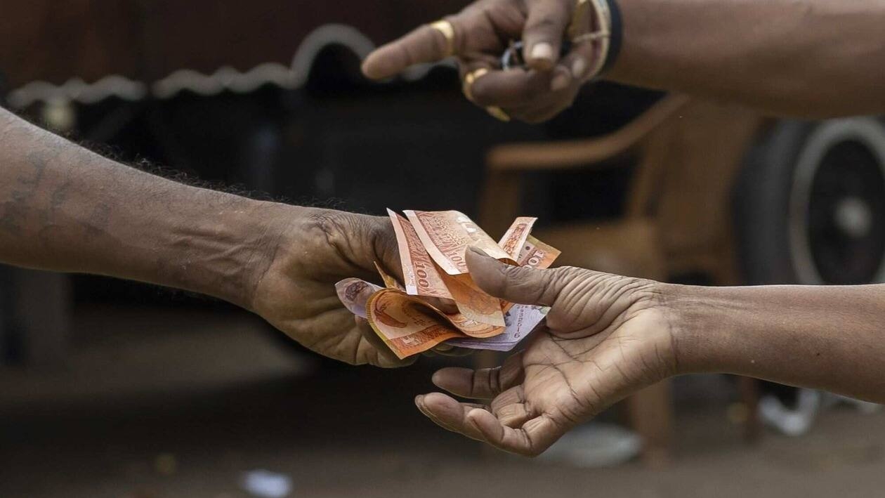 A customer receives Sri Lankan rupee banknotes at the open market in Colombo, Sri Lanka, on Wednesday, July 27, 2022. Sri Lanka is scheduled to announce its consumer prise index (CPI) figures on July 29. Photographer: Buddhika Weerasinghe/Bloomberg
