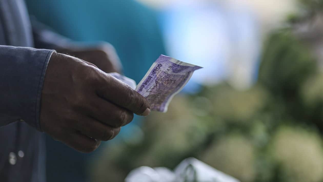 A shopper hands the Indian rupee banknotes to a vegetable vendor in Mumbai, India, on Wednesday, July 20, 2022. The rupee slid to all-time low of 80.06 per dollar on Tuesday, and has lost 2.4% over the past month, the third-worst performing Asian currency over the period. Photographer: Dhiraj Singh/Bloomberg