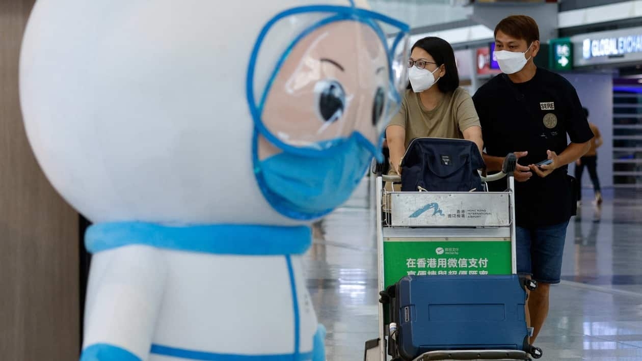 Travellers walk past an installation featuring a medical worker at the Hong Kong International Airport Departure Hall, amid the coronavirus disease (COVID-19) pandemic, in Hong Kong, China, August 1, 2022. REUTERS/Tyrone Siu