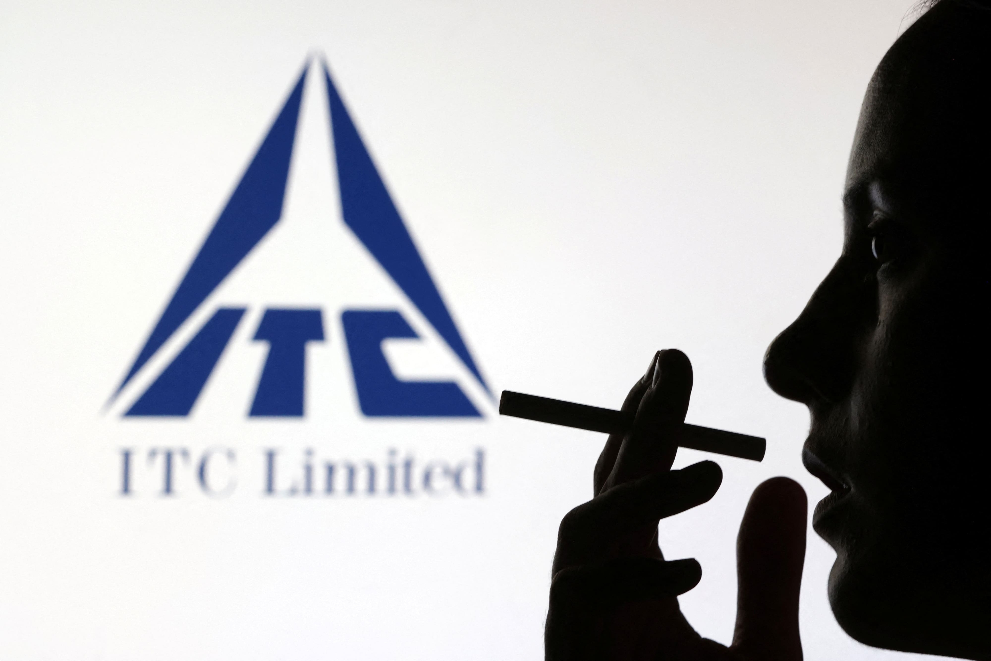 A woman poses with a cigarette in front of ITC Limited logo in this illustration taken July 26, 2022. REUTERS/Dado Ruvic/Illustration