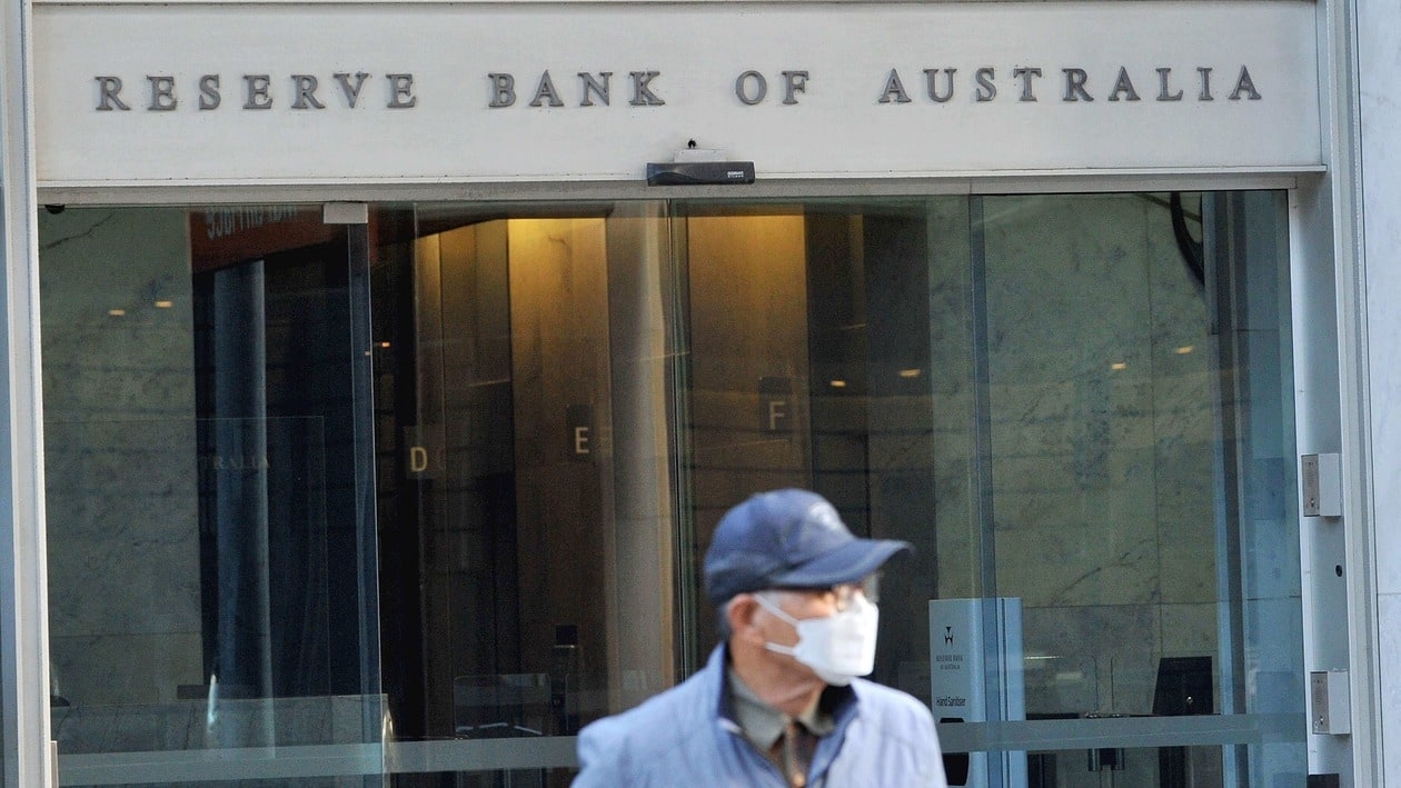 A man walks past the Reserve Bank of Australia building in the central business district of Sydney on June 7, 2022. Australia's central bank raised interest rates by a higher-than-expected half percentage point on June 7 and warned of more increases, trying to rein in significantly increased inflation. (Photo by Muhammad FAROOQ / AFP)