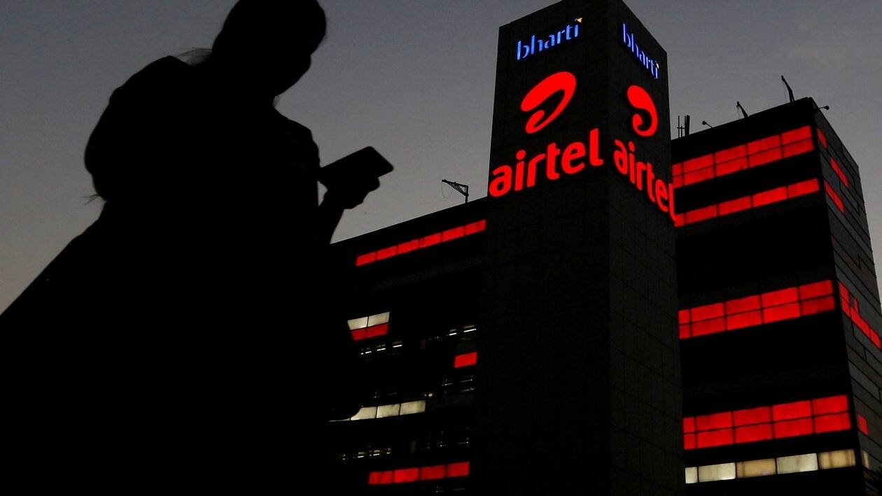 FILE PHOTO: A girl checks her mobile phone as she walks past the Bharti Airtel office building in Gurugram, previously known as Gurgaon, on the outskirts of New Delhi, India April 21, 2016. REUTERS/Adnan Abidi