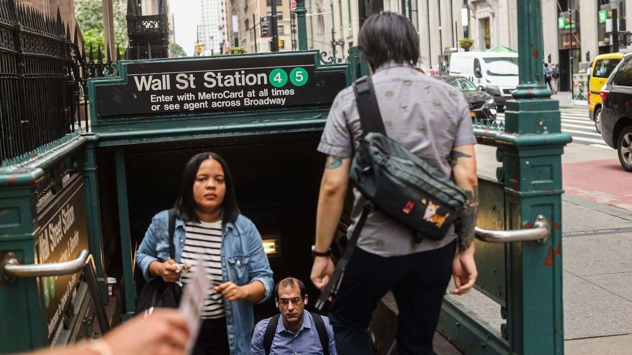Commuters exit from the Wall Street subway station in New York, US, on Monday, July 18, 2022. US stocks�fell amid a drop in big tech as investors assessed the outlook for corporate profits and risks to economic growth as central banks hike interest rates to combat runaway inflation. Photographer: Jonathan Alpeyrie/Bloomberg