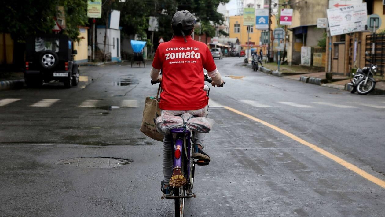 FILE PHOTO: A delivery worker of Zomato, an Indian food-delivery startup, rides her bicycle along a road in Kolkata, India, July 13, 2021. REUTERS/Rupak De Chowduri/File Photo