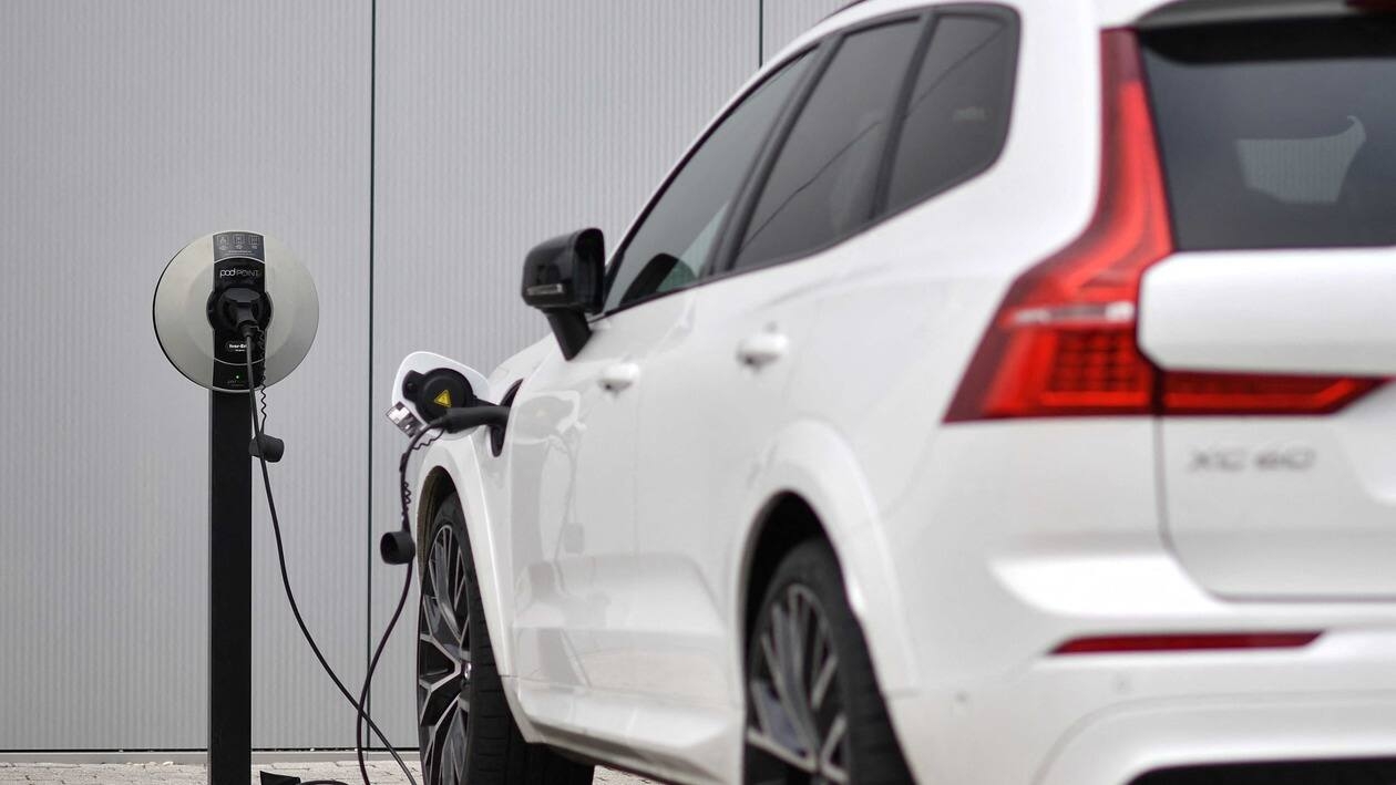 (FILES) In this file photo taken on March 2, 2021 a Volvo XC60 hybrid car is seen plugged into a charging point outside a Volvo dealership in Reading, west of London. - Britain, on June 14, 2022, axed its �1,500 ($1,800) subsidy for buyers of new plug-in cars as it focuses on other types of electric vehicles, but the news drew anger from the auto sector. (Photo by Ben STANSALL / AFP)