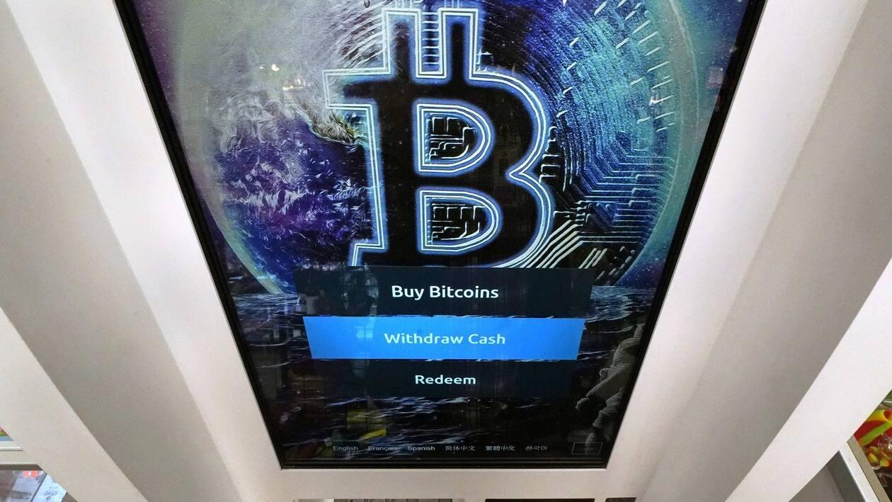 FILE - The Bitcoin logo appears on the display screen of a cryptocurrency ATM in Salem, N.H., Feb. 9, 2021. A bipartisan group of senators has proposed a bill to regulate cryptocurrencies. It's the latest attempt by Congress to formulate ideas on how to oversee a multibillion-dollar industry that has been racked recently by collapsing prices and lenders halting operations. (AP Photo/Charles Krupa, File)