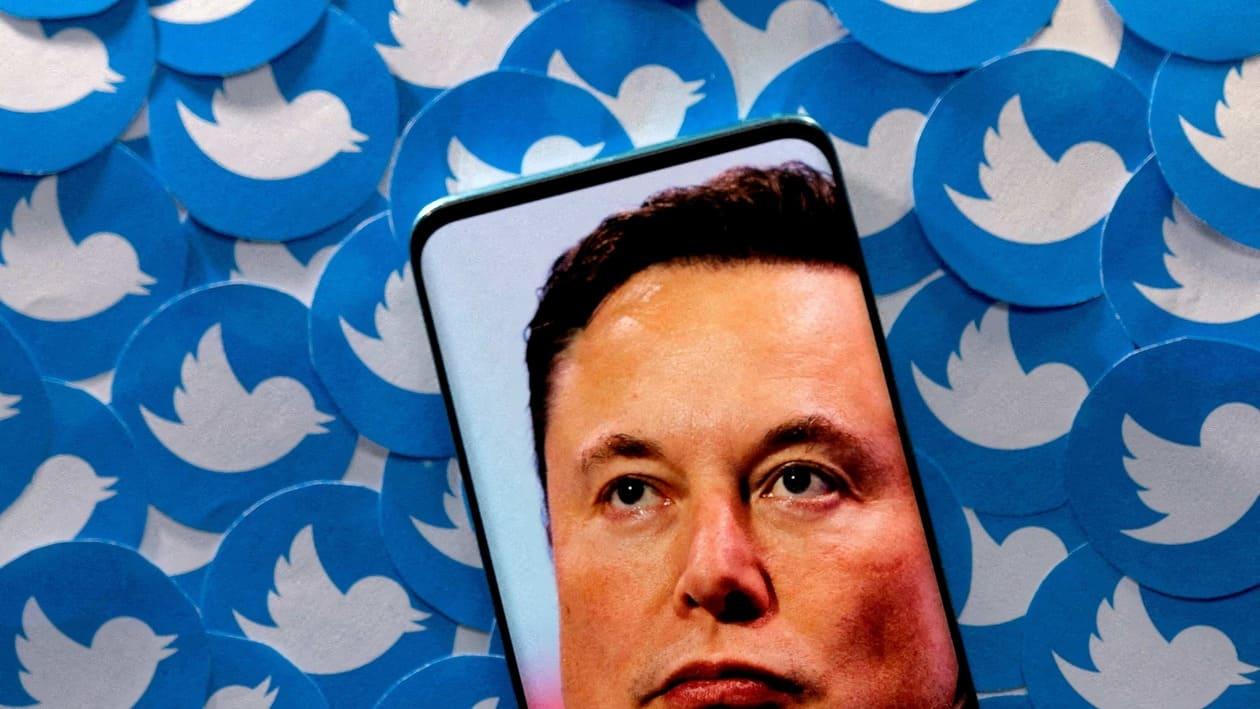 FILE PHOTO: An image of Elon Musk is seen on smartphone placed on printed Twitter logos in this picture illustration taken April 28, 2022. REUTERS/Dado Ruvic/Illustration/File Photo