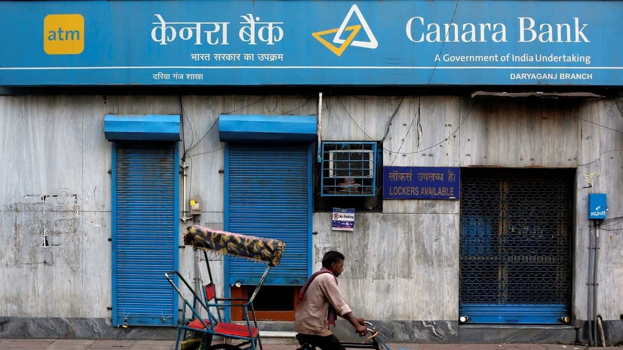 FILE PHOTO: A rickshaw puller passes the Canara Bank branch in the old quarters of Delhi, India, September 6, 2017. REUTERS/Adnan Abidi/File Photo