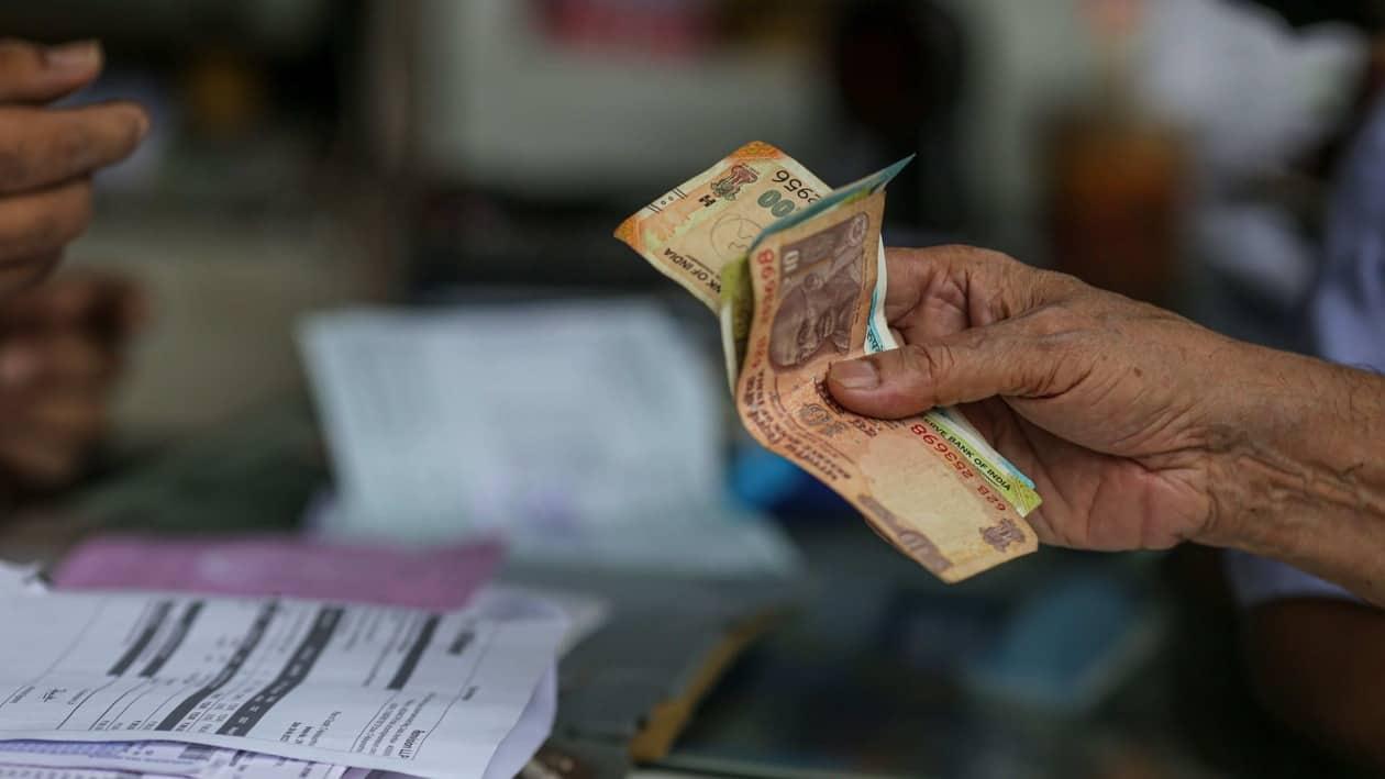 A shopper hands the Indian rupee banknotes to a shopkeeper in Mumbai, India, on Wednesday, July 20, 2022. The rupee slid to all-time low of 80.06 per dollar on Tuesday, and has lost 2.4% over the past month, the third-worst performing Asian currency over the period. Photographer: Dhiraj Singh/Bloomberg