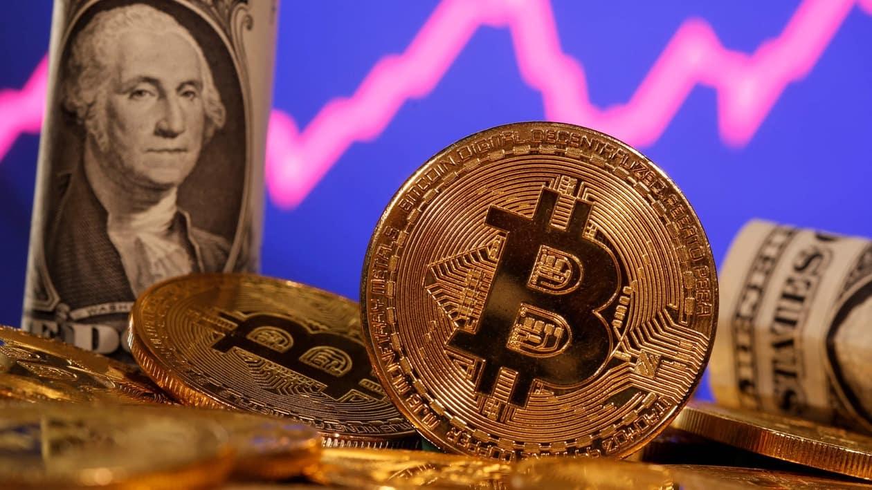 A representation of virtual currency bitcoin and a U.S. one dollar banknote are seen in front of a stock graph in this illustration taken January 8, 2021. REUTERS/Dado Ruvic/File Photo
