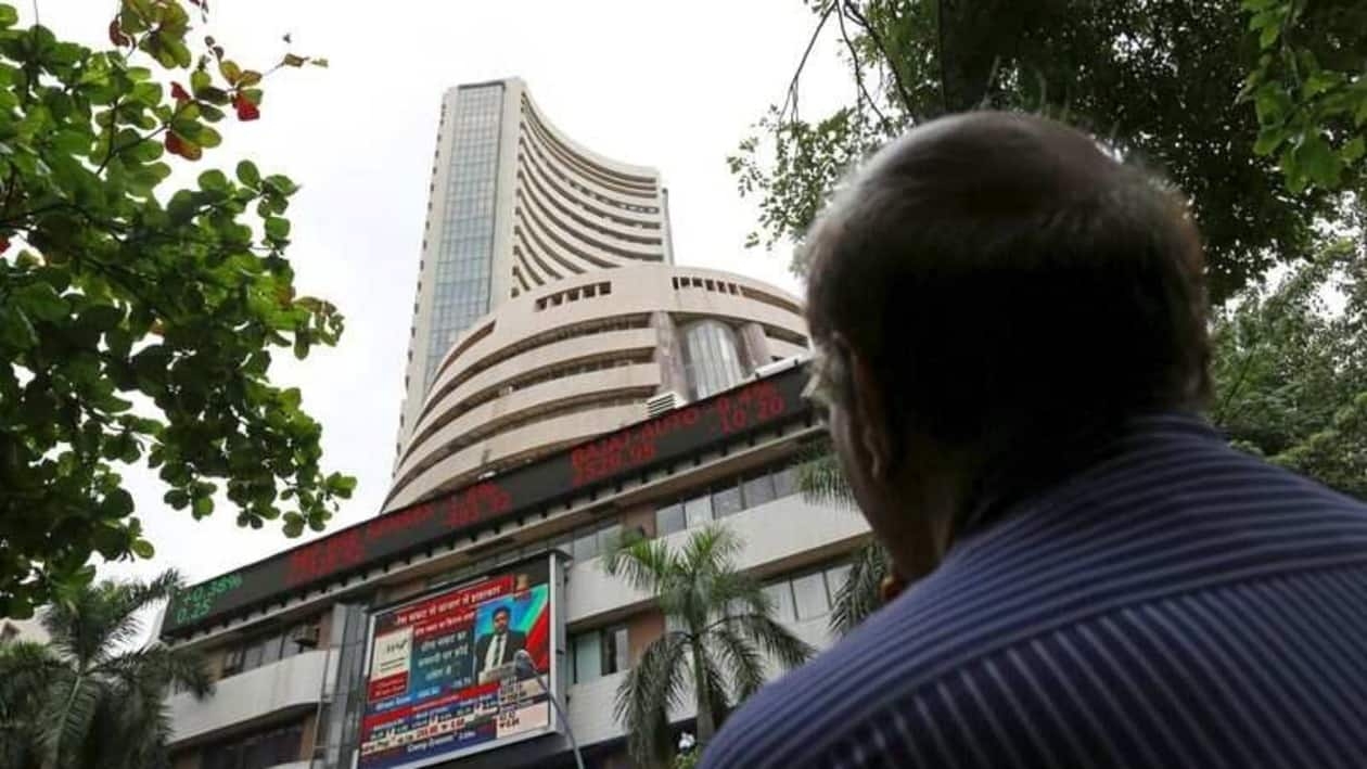 FILE PHOTO: A man looks at a screen across a road displaying the Sensex on the facade of the Bombay Stock Exchange (BSE) building in Mumbai, India, June 29, 2015. REUTERS/Danish Siddiqui