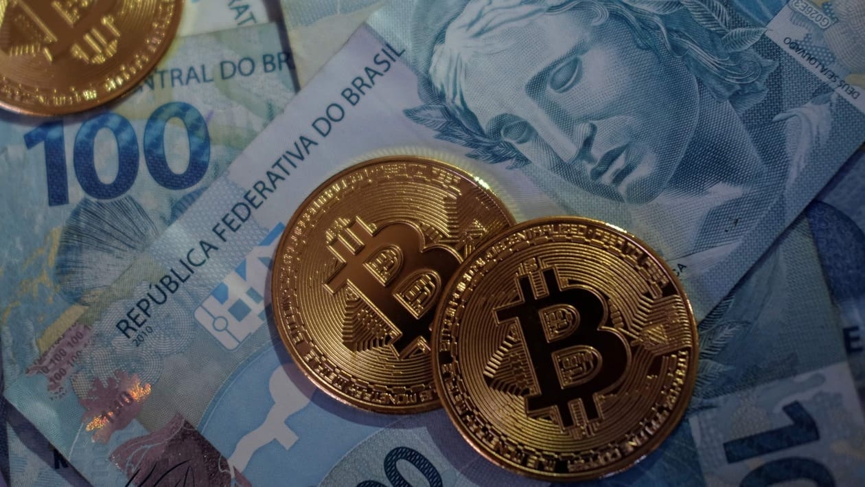 FILE PHOTO: Representations of Bitcoin cryptocurrency are seen over Brazilian Real notes in this illustration picture taken May 25, 2021. REUTERS/Ricardo Moraes/Illustration/File Photo