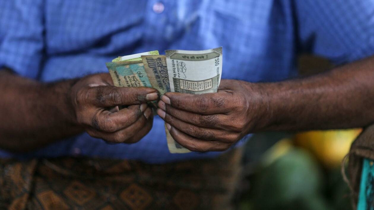 A vegetable vendor counts Indian rupee banknotes at a vegetable market in Mumbai, India, on Wednesday, July 20, 2022. The rupee slid to all-time low of 80.06 per dollar on Tuesday, and has lost 2.4% over the past month, the third-worst performing Asian currency over the period. Photographer: Dhiraj Singh/Bloomberg