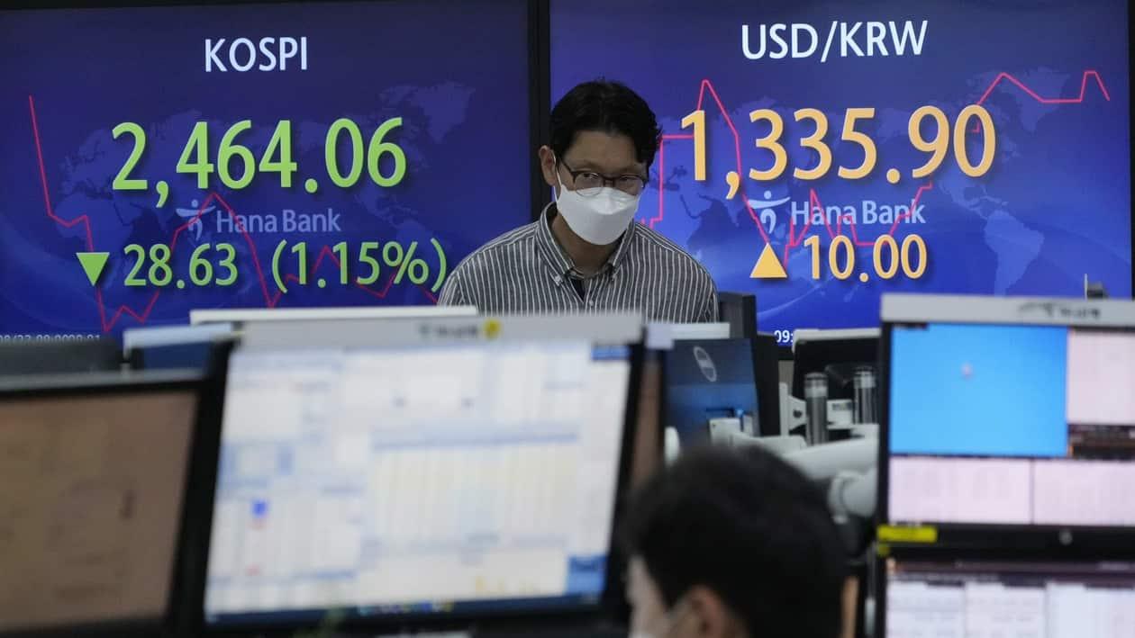 A currency trader watches monitors in front of screens showing the Korea Composite Stock Price Index (KOSPI), left, and the exchange rate of South Korean won against the U.S. dollar at the foreign exchange dealing room of the KEB Hana Bank headquarters in Seoul, South Korea, Monday, Aug. 22, 2022. Asian stock markets were mixed Monday after China cut an interest rate that affects mortgage lending while investors looked ahead to this week’s Federal Reserve conference for signals about more possible U.S. rate hikes to cool surging inflation. (AP Photo/Ahn Young-joon)